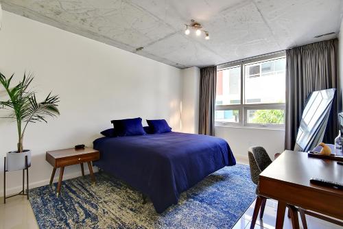 a bedroom with a blue bed and a piano at Miami Midtown Luxury Apartment in Miami