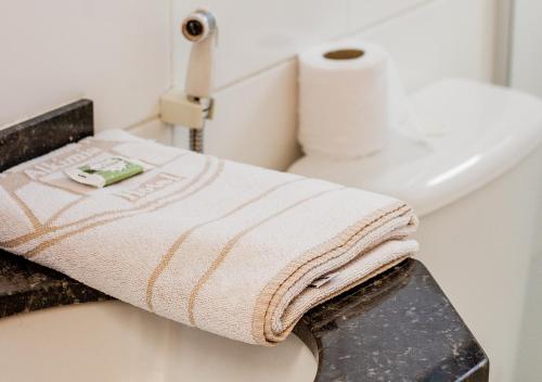 een badkamer met een handdoek op een aanrecht naast een toilet bij Alkimia Hotel in Campo Grande