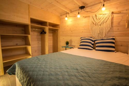 sypialnia z łóżkiem z niebiesko-białymi poduszkami w obiekcie Domki U Huberta Międzywodzie w mieście Międzywodzie