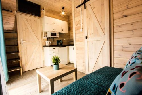 mały pokój z łóżkiem i stołem oraz kuchnią w obiekcie Domki U Huberta Międzywodzie w mieście Międzywodzie