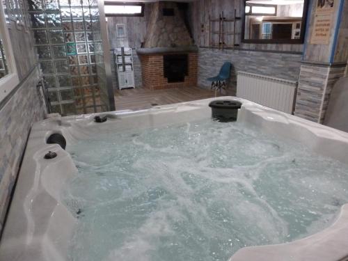 uma banheira de hidromassagem num quarto com lareira em Casa Rural & SPA Mirador Sierra de Béjar em Guijo de Ávila