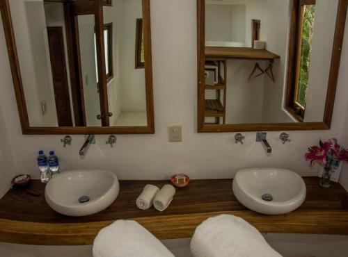 a bathroom with two sinks and mirrors on a wooden counter at El Alquimista Yoga Spa in Zipolite