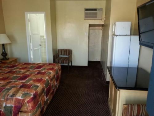 a hotel room with a bed and a refrigerator at Mt. Gleason Motorlodge in Sunland
