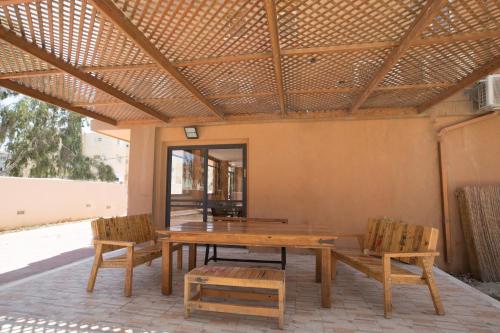 Hadass Desert Inn في ديمونة: طاولة وكراسي خشبية على الفناء