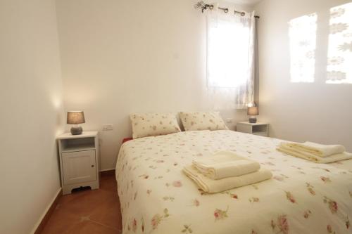 a bedroom with a bed with two towels on it at Hadass Desert Inn in Dimona