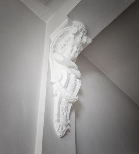 a white statue on the corner of a wall at B&B Villa Chantecler in Bruges