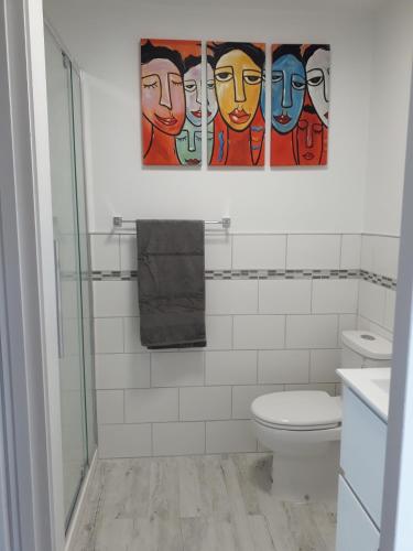 a bathroom with a toilet and a painting on the wall at The Old Sunday School in Dunedin