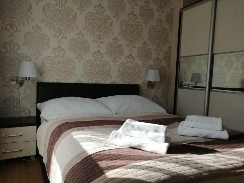 a bedroom with a large bed with two towels on it at Apartament Mariva B03 z ogródkiem - Pobierowo - blisko morza - przy kompleksie Grand Laola SPA in Pobierowo