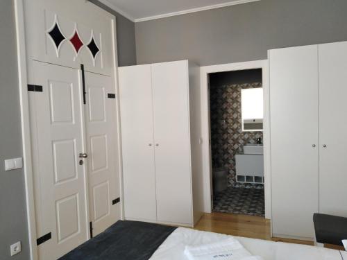 a bedroom with white cabinets and a door at ALM SANTA LUZIA in Guimarães