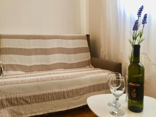 una bottiglia di vino seduta su un tavolo accanto a un divano di Sobe Bosiljka a Nin