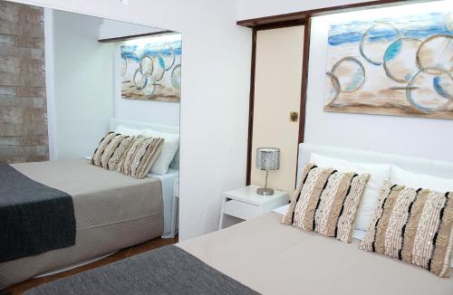 a bedroom with two beds and a mirror at Casa da Sereia in Sesimbra