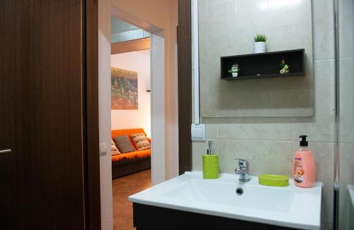 baño con lavabo, espejo y sofá en Casa da Sereia, en Sesimbra