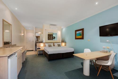 a bedroom with a bed and a desk and a table at Ballina Beach Resort in Ballina
