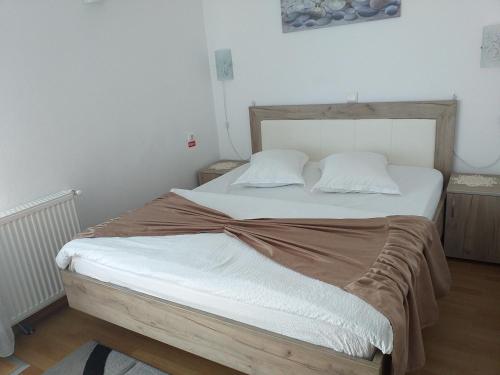 a bedroom with a large bed with white sheets at Casa Raluca in Arieşeni