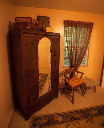 a dresser with a mirror and a chair in a room at Nolichuckey Bluffs Bed & Breakfast Cabins in Greeneville