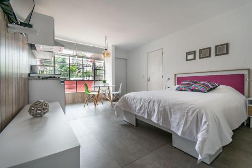 ein Schlafzimmer mit einem großen Bett und einem Tisch in der Unterkunft JUUB Colorful, Studio in New Polanco District (R1) in Mexiko-Stadt