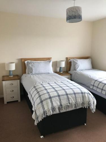 a bedroom with two beds and two night stands at Heb Holiday, Self Catering Accommodation, Isle of Benbecula in Gramisdale