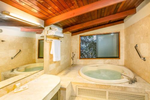 uma grande casa de banho com banheira e lavatório em Decameron El Pueblo em Lima