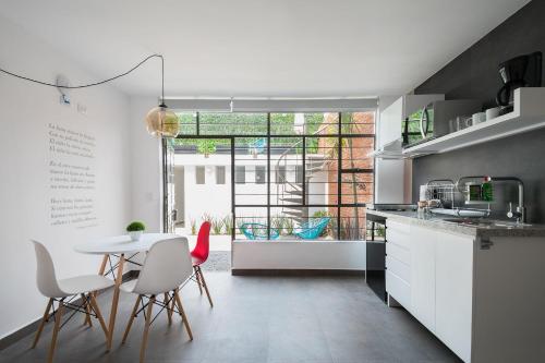 a kitchen with white cabinets and a table and chairs at JUUB New Beautiful Suite Nuevo Polanco (R2) in Mexico City