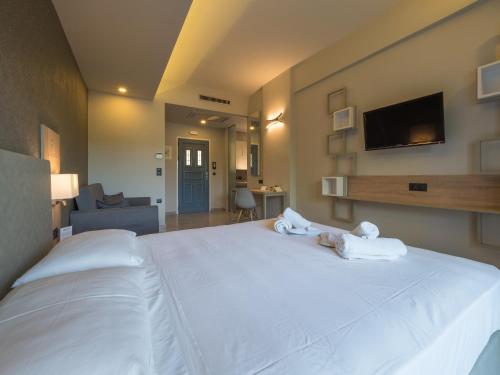 a bedroom with a large white bed with two stuffed animals on it at Paradise Resort in Finikounta