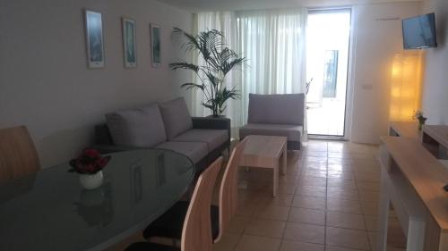 a living room with a couch and a glass table at Calatabarca B&B in Tabarca