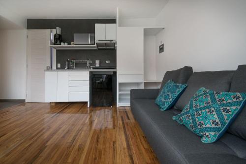 ein Wohnzimmer mit einem Sofa und einer Küche in der Unterkunft JUUB In the Heart of New Polanco (R4) in Mexiko-Stadt