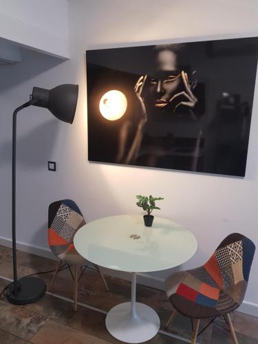 a white table with chairs and a lamp in a room at Suite del Pecado in Babilafuente