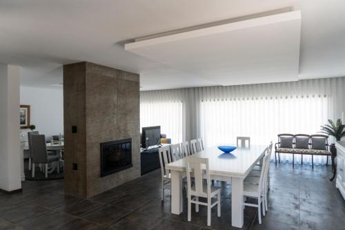 a dining room and living room with a white table and chairs at Casa Guarda Rios - São Pedro do Sul in São Pedro do Sul