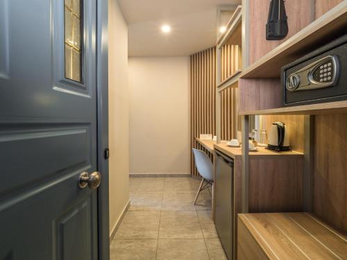 a hallway with a door and a table with a microwave at Paradise Resort in Finikounta