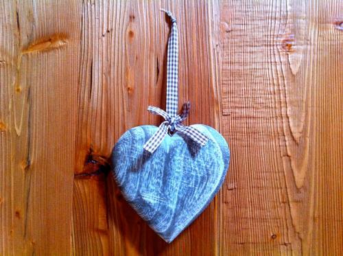 a heart shaped object hanging on a wooden wall at Mortirolo in Mazzo di Valtellina