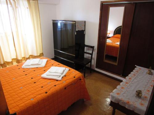 Lajes das Flores的住宿－Casa L&M，一间卧室配有橙色的床和镜子