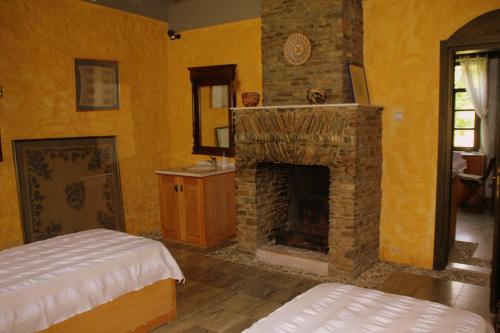 a room with a fireplace and a bed and a mirror at Eski Doganbey Houses in Doğanbey