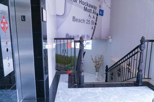 a lobby with a staircase with a sign on the wall at Hotel Mint JFK Airport in Queens