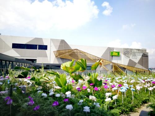 a garden of flowers in front of a building at HostaHome Suites at I-City, Central Mall in Shah Alam