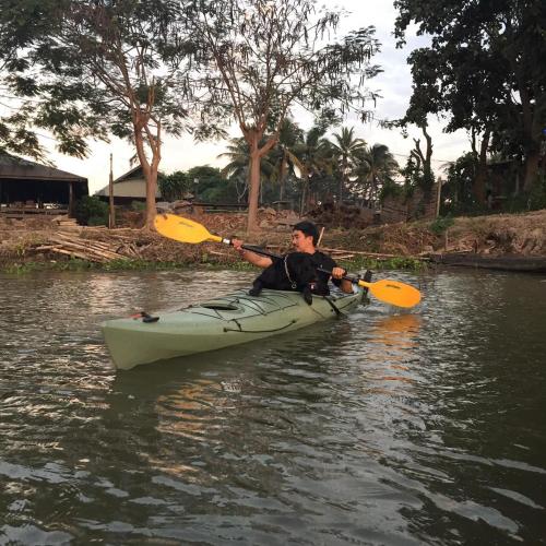 a man is in a kayak in the water at Monsamkien Farmstay in Phayao