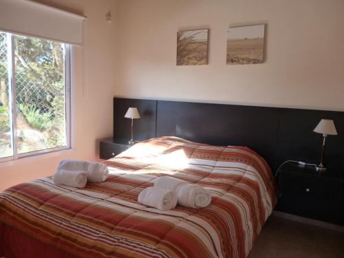 une chambre avec un lit avec deux serviettes dessus dans l'établissement Terra Magna, à Mar de las Pampas