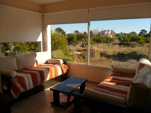 sala de estar con sofá y ventana grande en Terra Magna en Mar de las Pampas