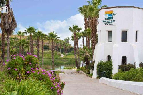 a building with a sign on it next to a body of water at Real del Mar Golf Resort in Tijuana