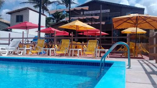 - une piscine avec des chaises et des parasols à côté d'un bâtiment dans l'établissement Pousada Galeão Pirata, à Abrantes