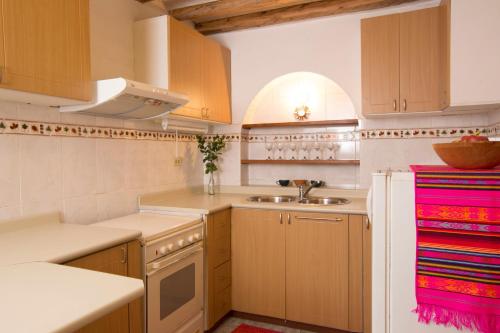 uma cozinha com armários de madeira e um lavatório em Casa LunaLoma - Boutique Apartments em Quito
