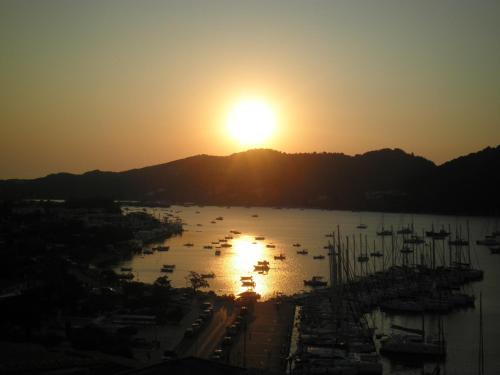 a sunset view of a harbor with boats in the water at Babis in Skiathos