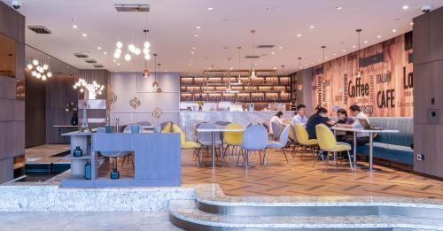 a lobby of a restaurant with people sitting at tables at Mercure Shanghai Hongqiao South in Shanghai
