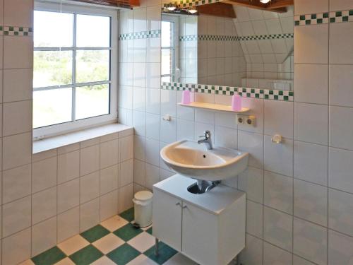a bathroom with a sink and a mirror at Haus Nordlicht Ferienwohnung *Bi a Maln* in Nebel