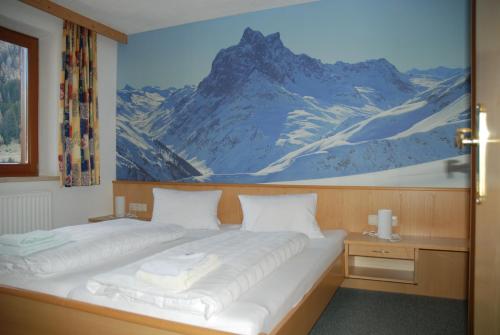 sypialnia z dwoma łóżkami i obrazem na ścianie w obiekcie Haus Saumspitz w mieście Sankt Anton am Arlberg
