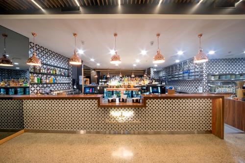 a bar with a counter with a lot of drinks at Airlie Beach Hotel in Airlie Beach