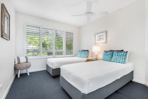 a bedroom with two beds and a chair at Sunshine Vista in Sunshine Beach