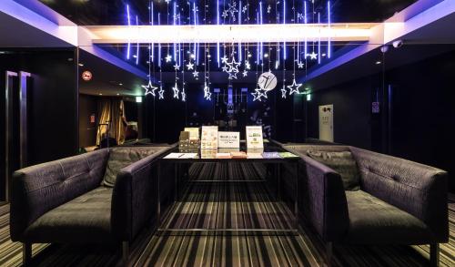 a bar with two couches in a room with lights at Vendome East Inn in Taipei