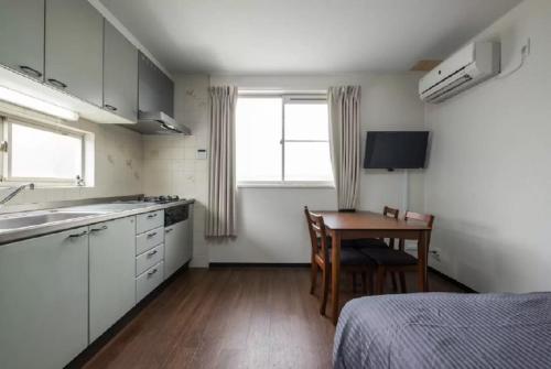 a small kitchen with a table and a bed at Happy Osaka House in Osaka