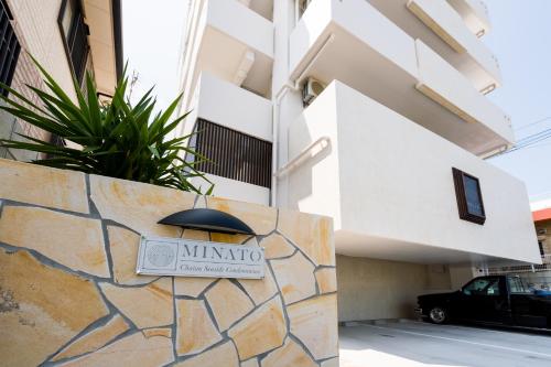 a sign on a stone wall in front of a building at MINATO Chatan Seaside Condominium in Chatan