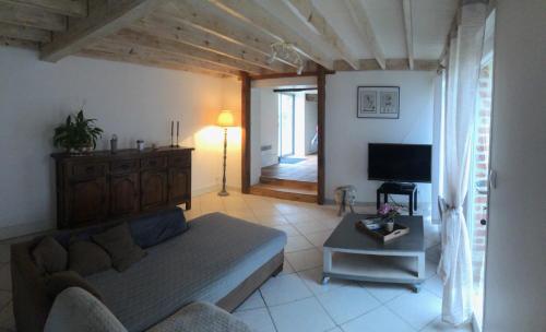 a living room with a couch and a television at Maison a la campagne in Cléty